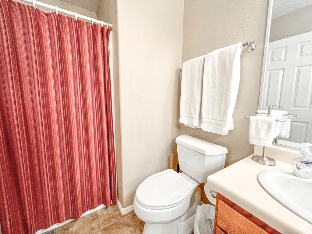 Bathroom featuring toilet, vanity, and tile patterned flooring