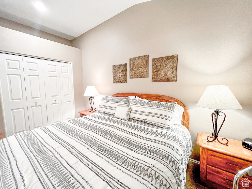 Bedroom with a closet and lofted ceiling