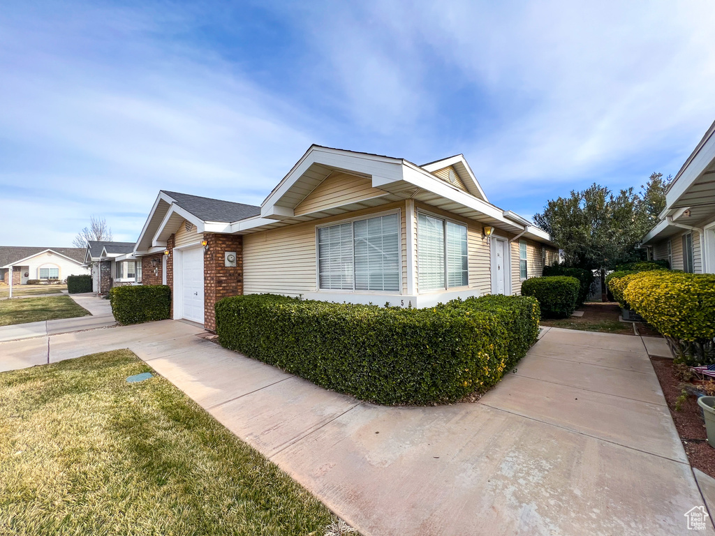 View of side of property featuring a yard and a garage