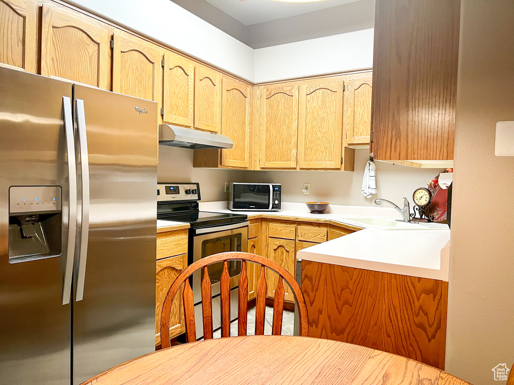 Kitchen with sink, light brown cabinets, and stainless steel appliances