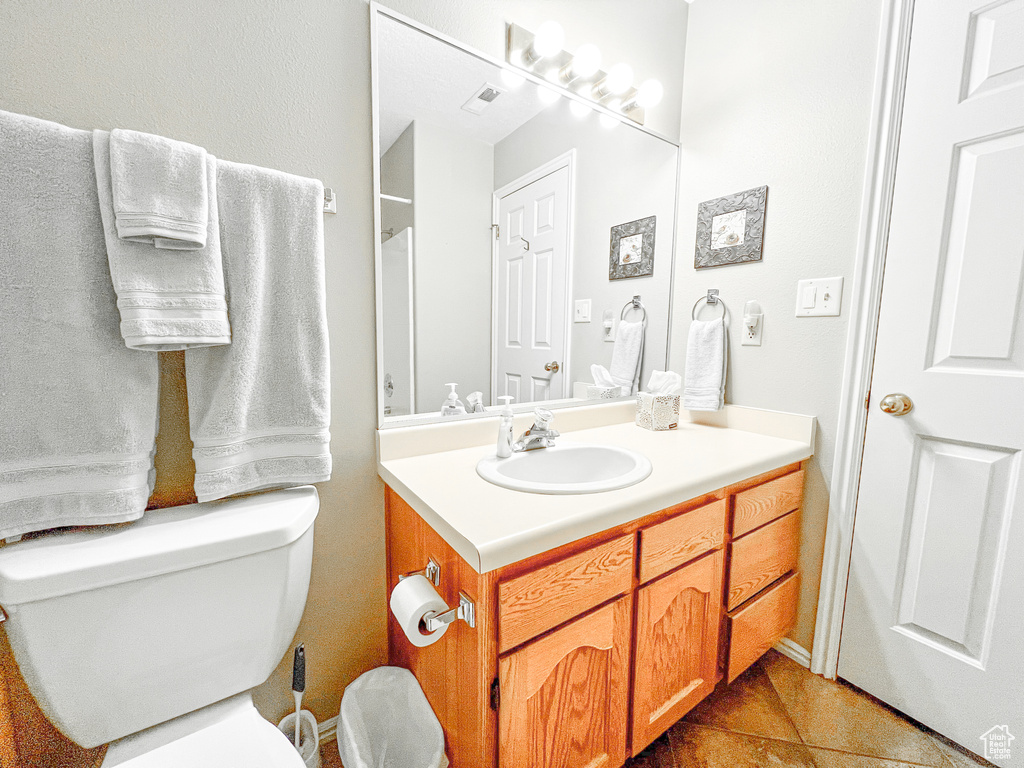 Bathroom featuring vanity, toilet, and tile patterned floors