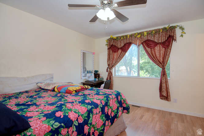 Bedroom featuring ceiling fan and light hardwood / wood-style flooring
