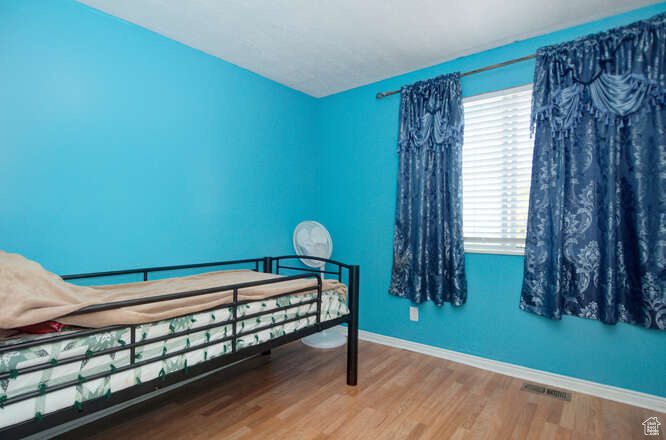 Bedroom with hardwood / wood-style floors