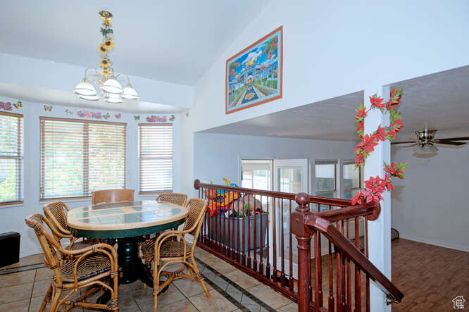 Tiled dining area with vaulted ceiling and a notable chandelier