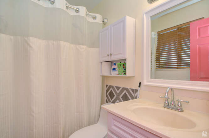 Bathroom featuring vanity, toilet, and a shower with shower curtain