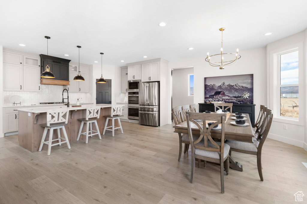 Dining room featuring a chandelier, recessed lighting, baseboards, and light wood finished floors