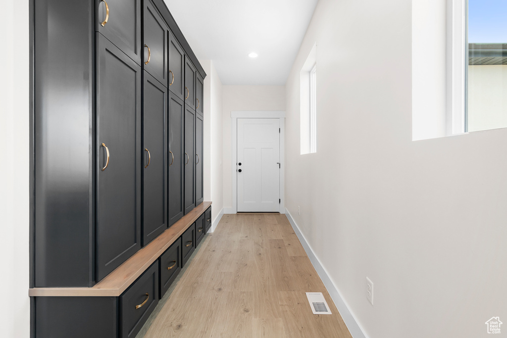 Mudroom with light wood-type flooring, visible vents, baseboards, and a wealth of natural light