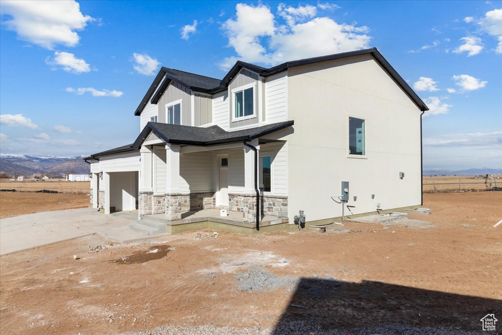 Exterior space with a mountain view, a garage, and covered porch