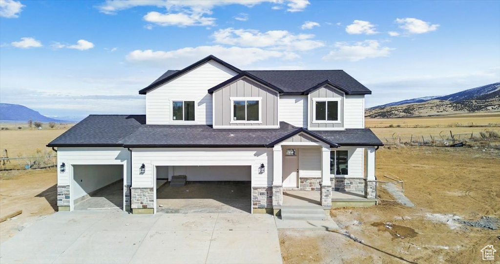 View of front of property with a mountain view, a garage, and covered porch