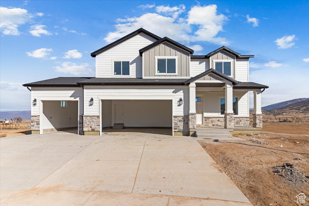 Craftsman inspired home featuring a porch, a garage, and a mountain view