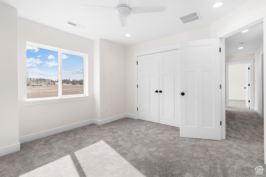 Unfurnished bedroom with a closet, baseboards, visible vents, and carpet flooring