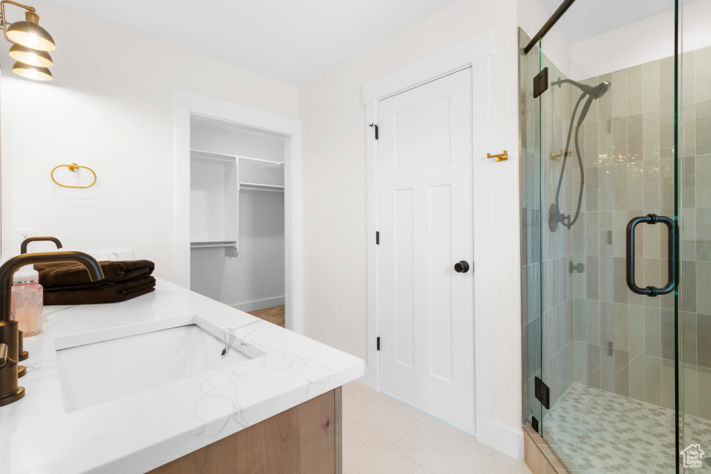 Full bathroom with a shower stall, a spacious closet, and vanity