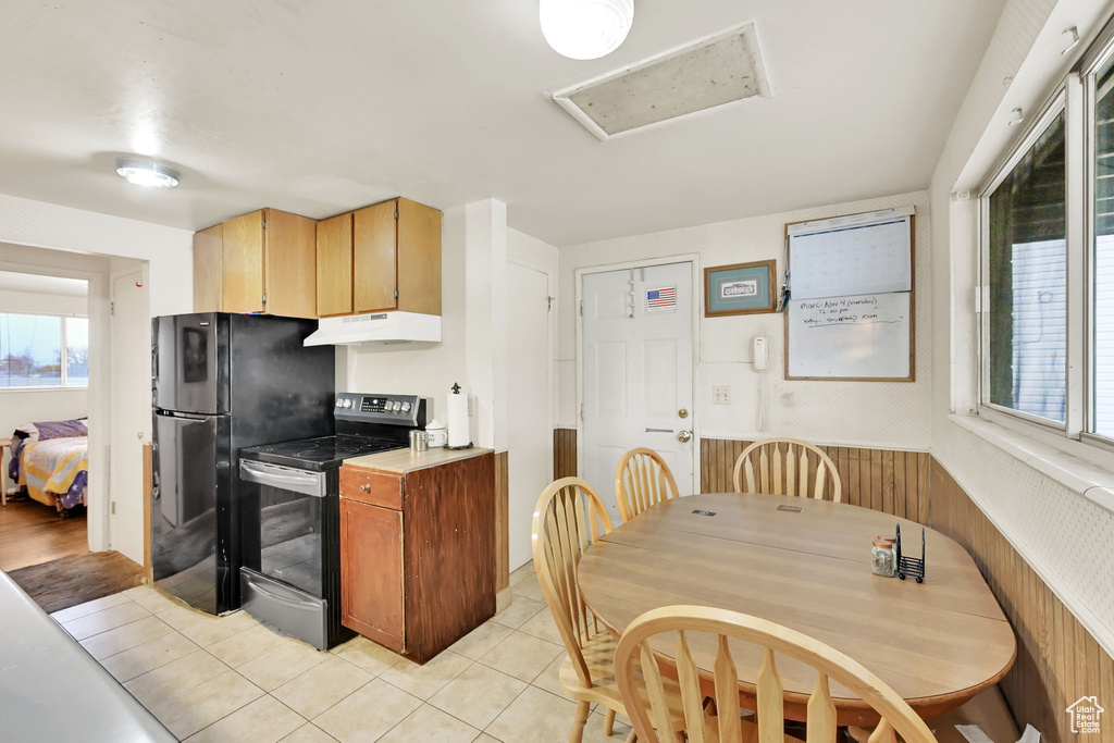 Kitchen featuring black fridge, stainless steel range with electric cooktop, and light tile patterned floors