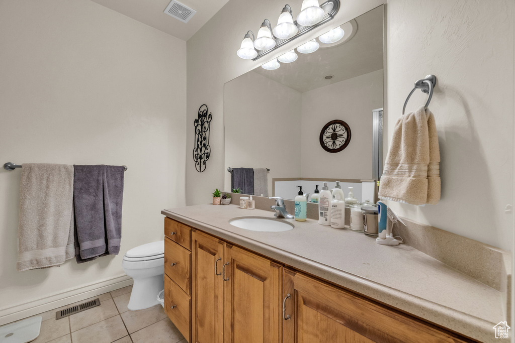 Bathroom with vanity, toilet, and tile patterned floors