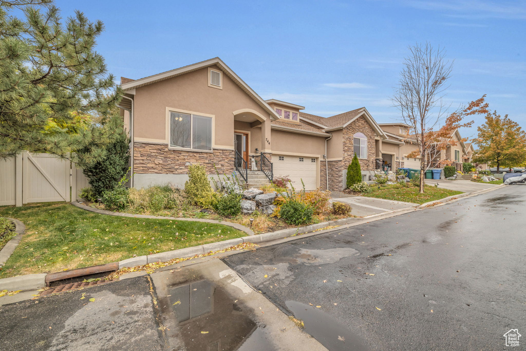 View of front of property featuring a front yard and a garage