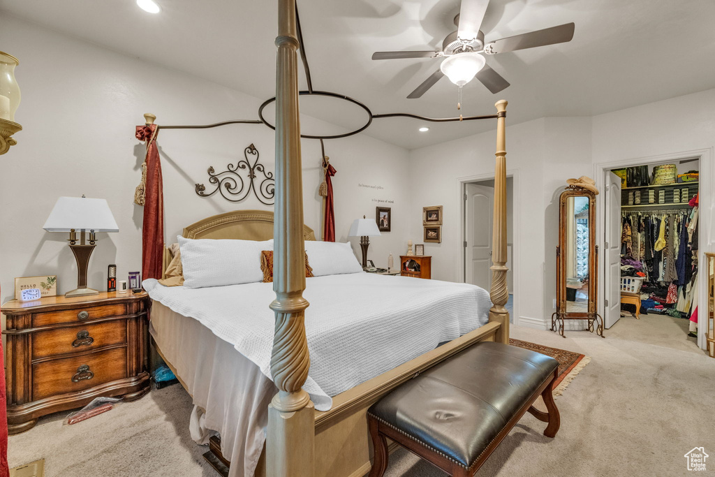 Carpeted bedroom with a closet, ceiling fan, and a spacious closet