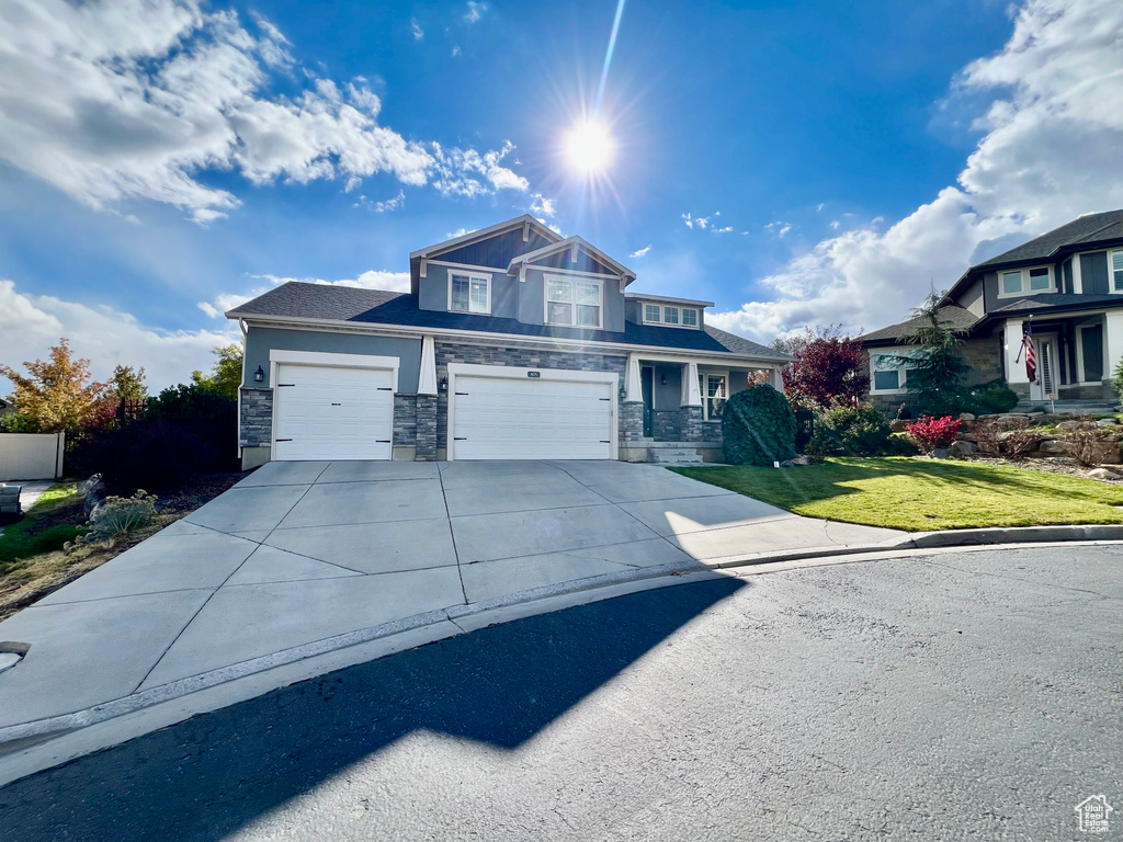 Craftsman house featuring a front lawn and a garage