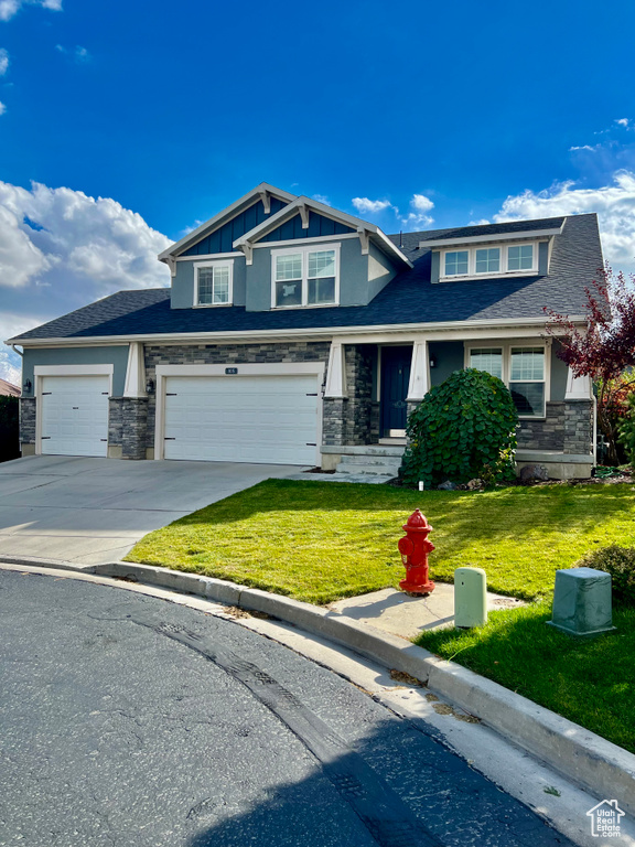 Craftsman inspired home with a front yard and a garage