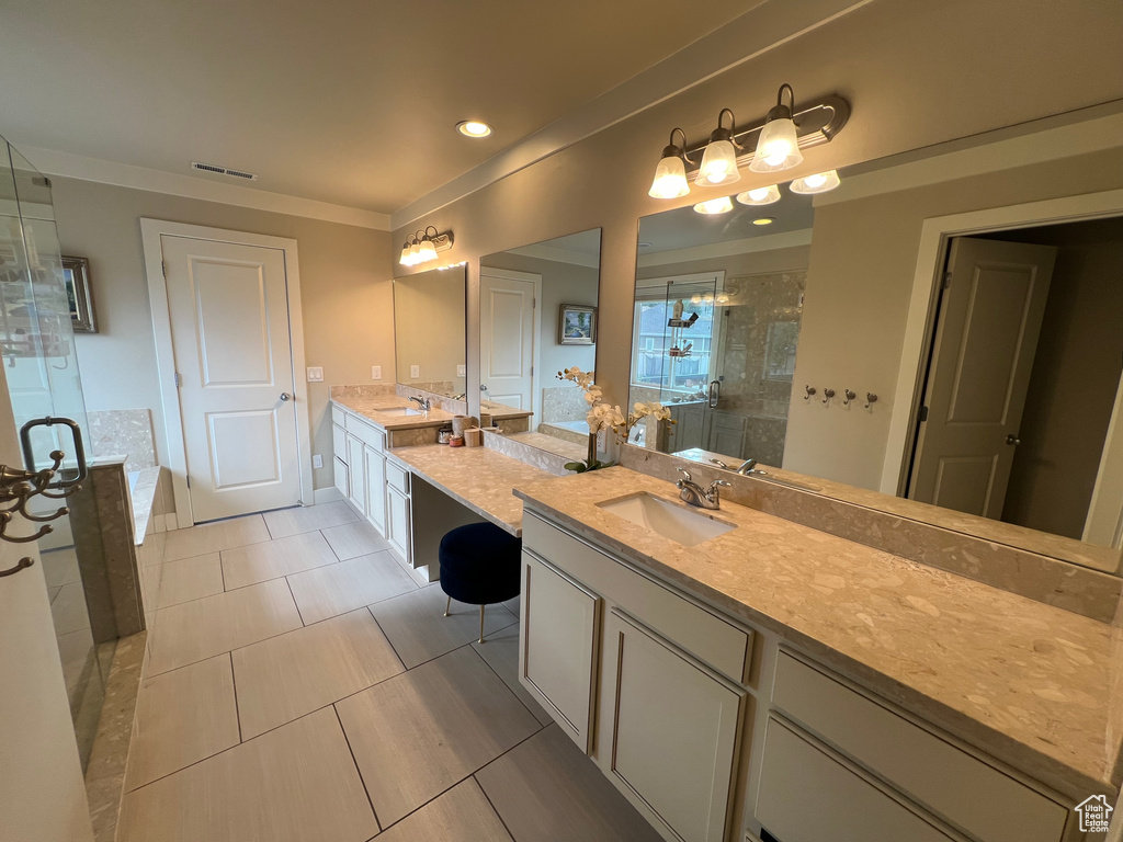 Bathroom with vanity, a shower with shower door, and tile patterned floors