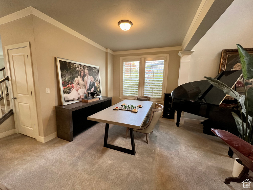 Office space with decorative columns, light carpet, and ornamental molding