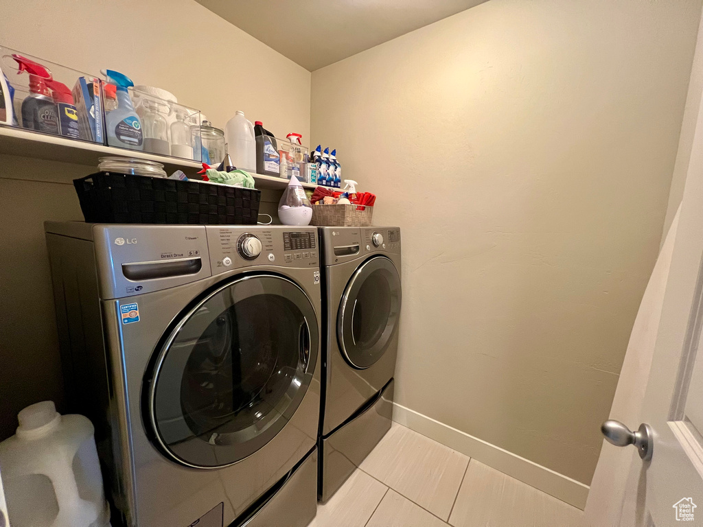 Laundry room with light tile patterned flooring and separate washer and dryer