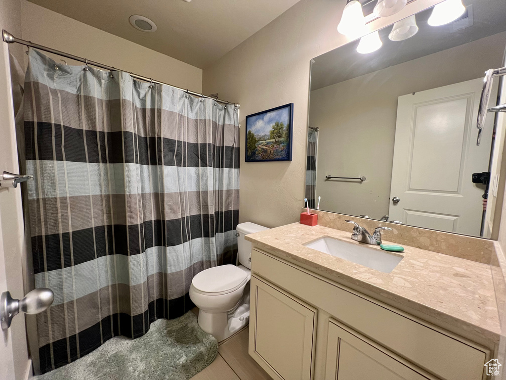 Bathroom with vanity, toilet, tile patterned floors, and a shower with curtain