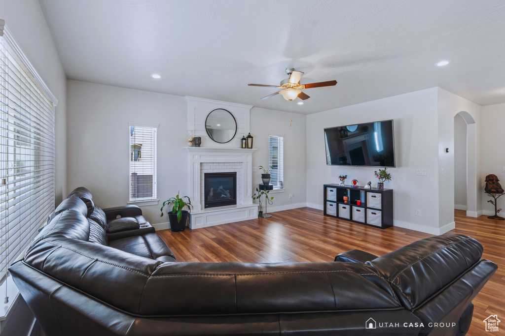 Living room with ceiling fan and hardwood / wood-style floors