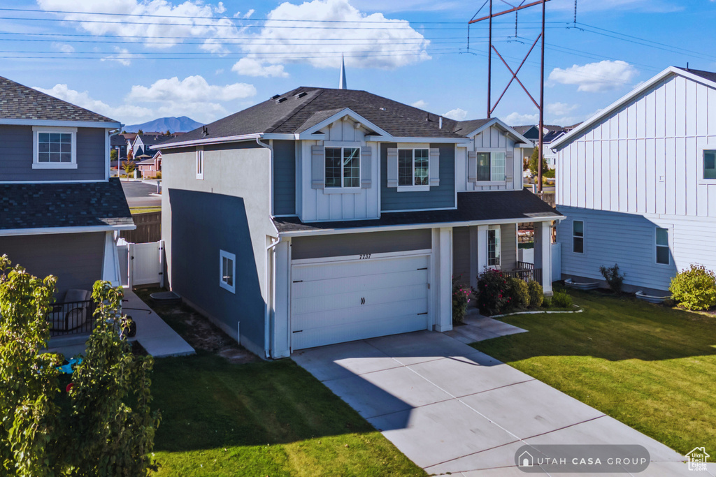 Front of property featuring a front yard and a garage