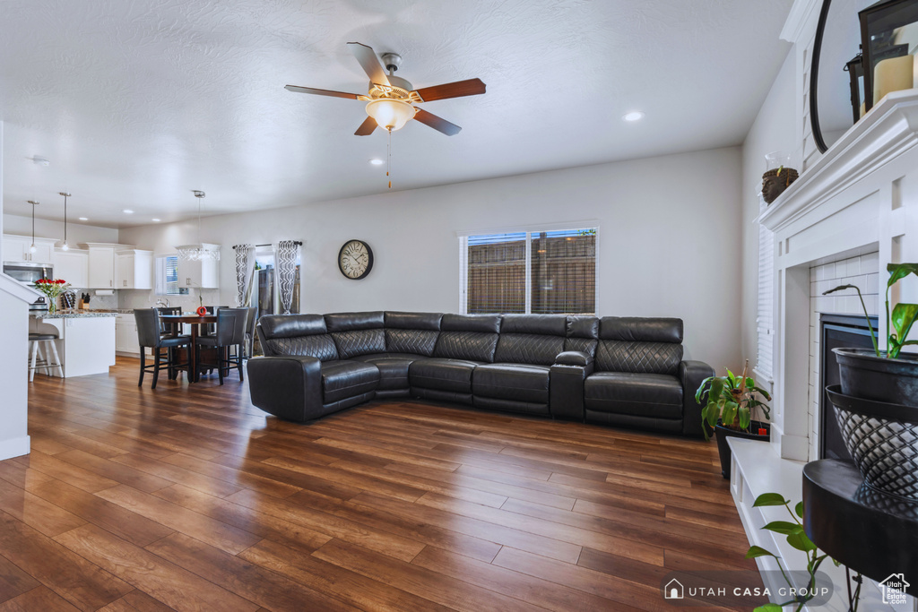 Living room with dark hardwood / wood-style floors, a fireplace, and ceiling fan