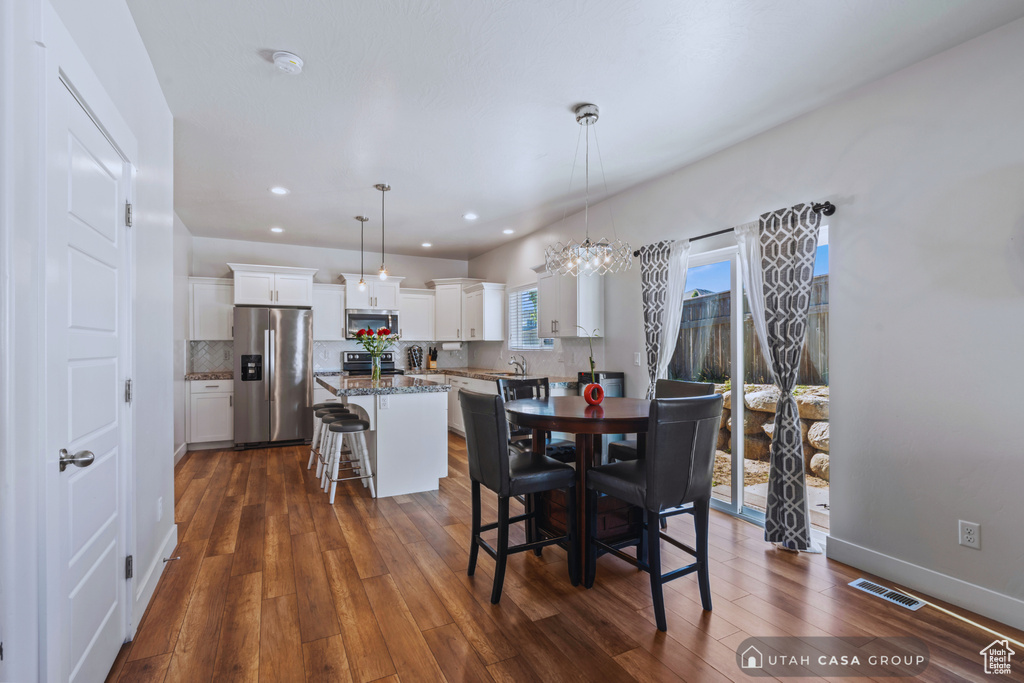 Dining space with sink and dark hardwood / wood-style flooring