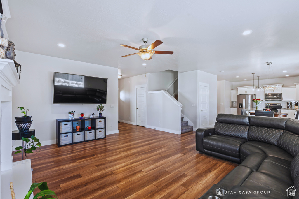 Living room with dark wood-type flooring and ceiling fan