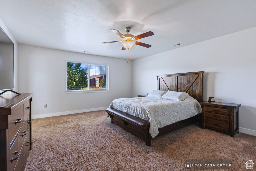 Carpeted bedroom featuring ceiling fan