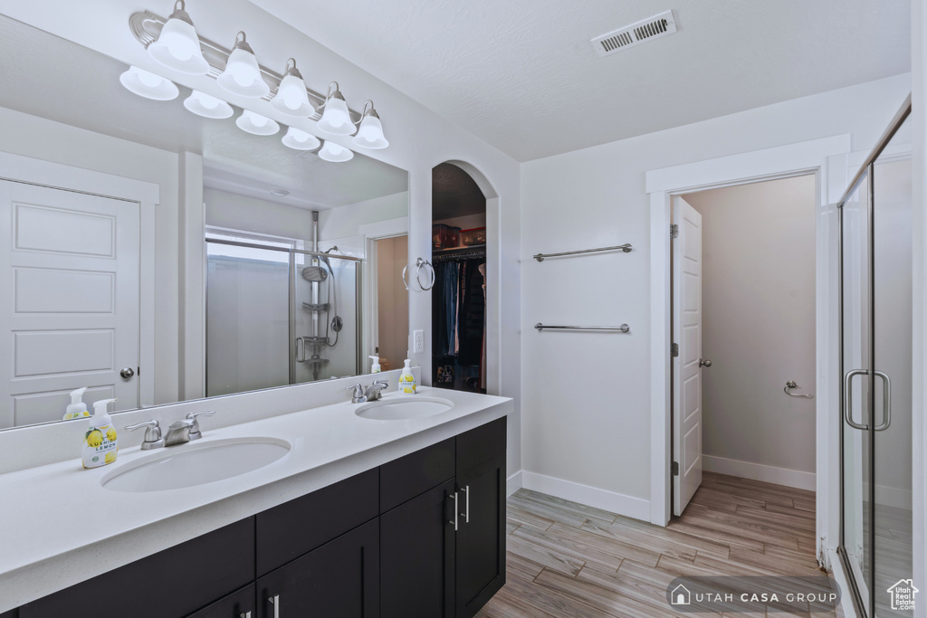 Bathroom featuring vanity, an enclosed shower, and hardwood / wood-style flooring