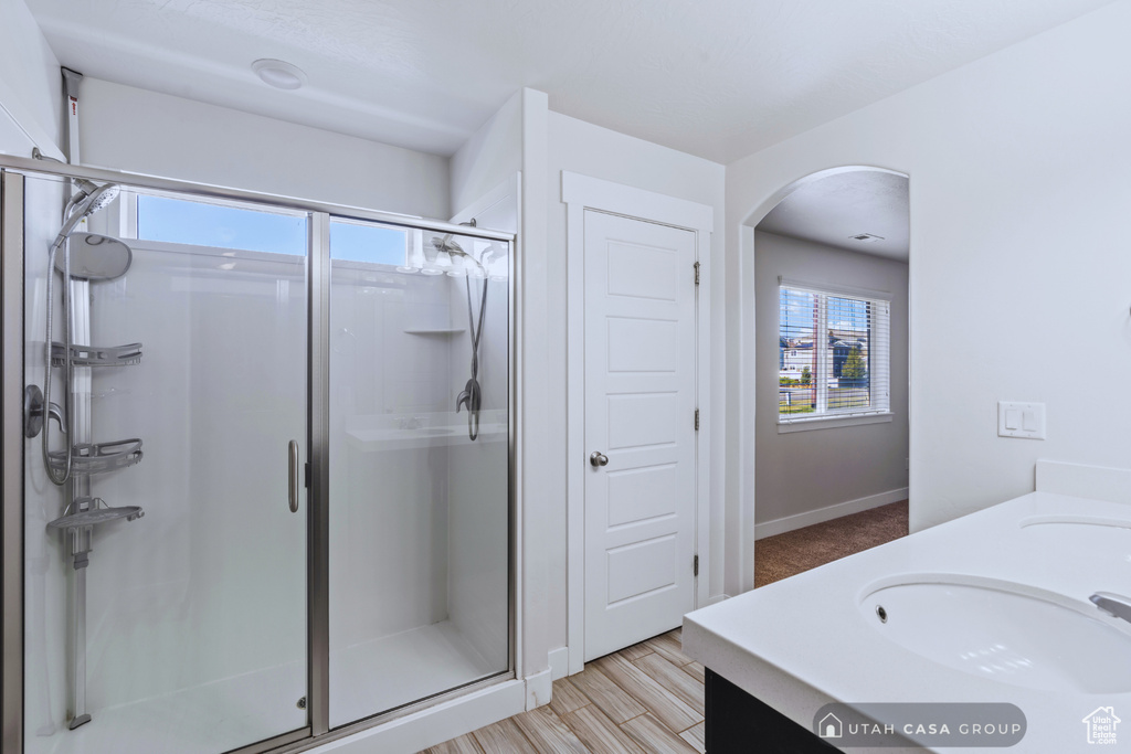 Bathroom with vanity, walk in shower, and wood-type flooring