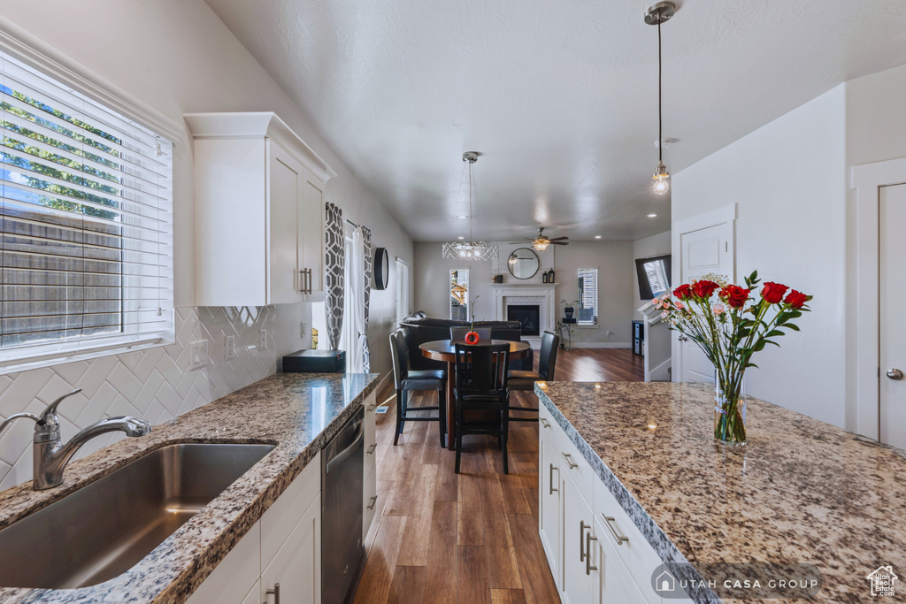 Kitchen with sink, stainless steel dishwasher, dark hardwood / wood-style floors, and white cabinets