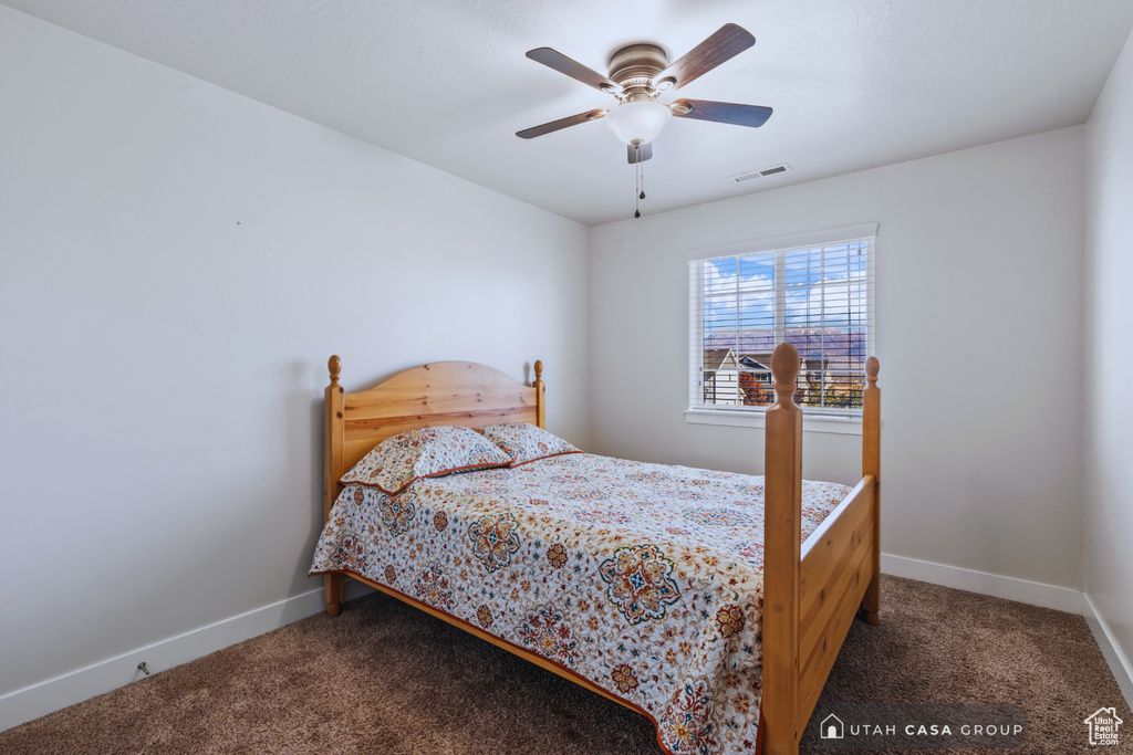 Bedroom with dark carpet and ceiling fan