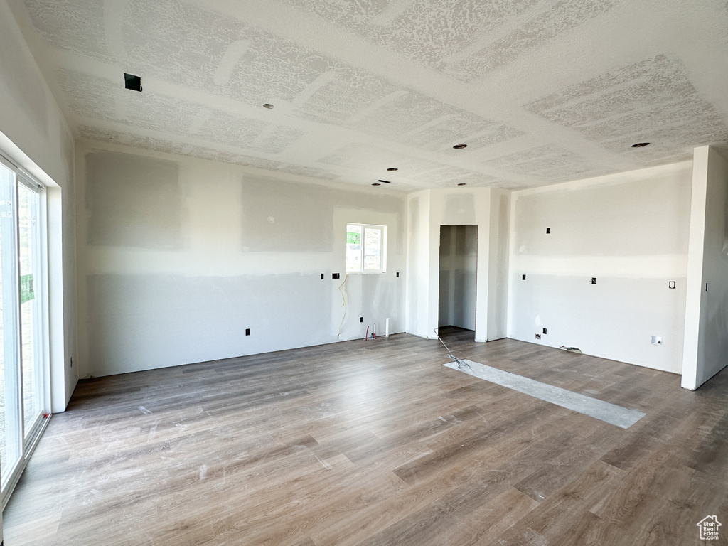 Empty room with hardwood / wood-style floors and a healthy amount of sunlight