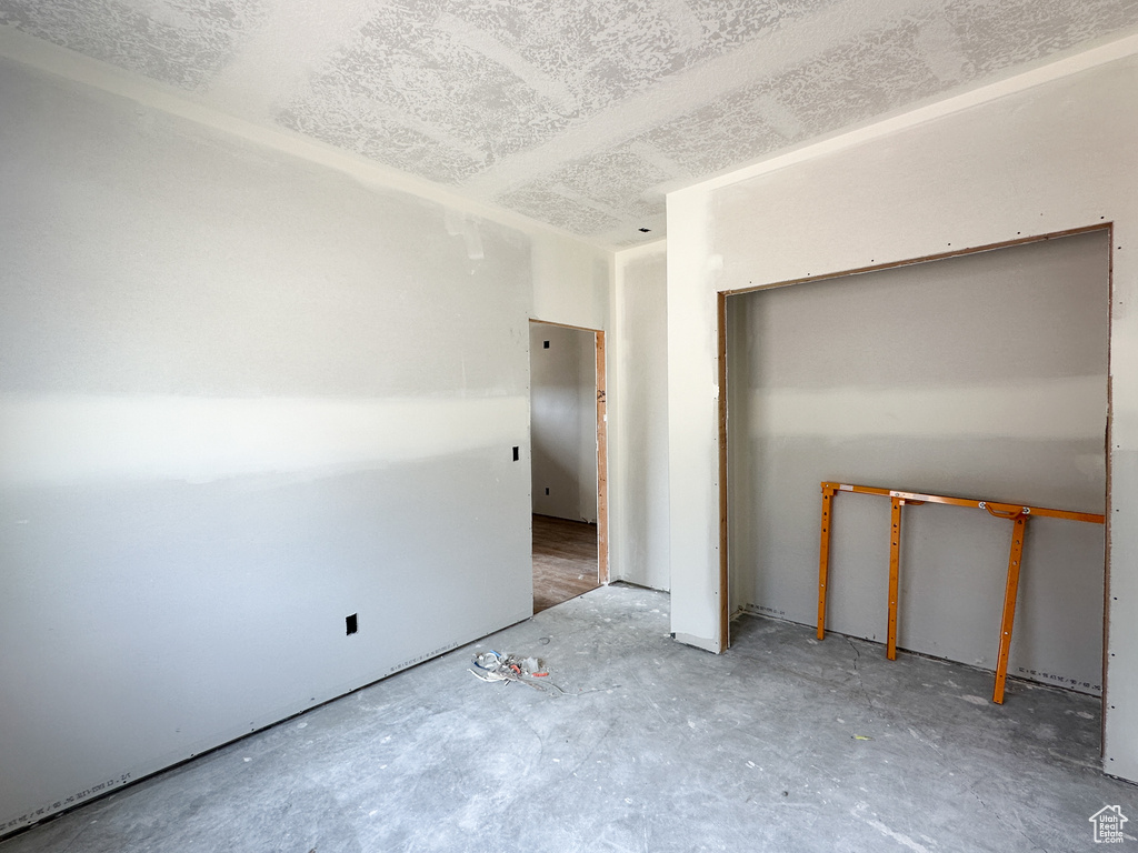 Unfurnished bedroom featuring concrete flooring