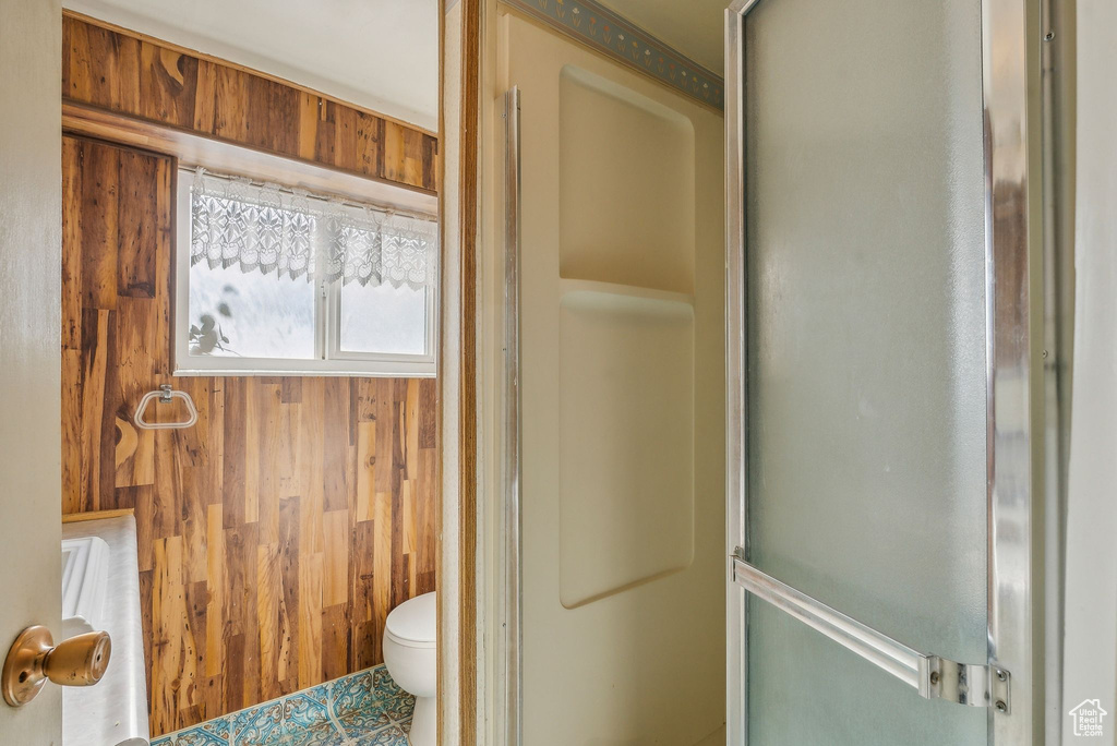 Bathroom featuring wooden walls and toilet