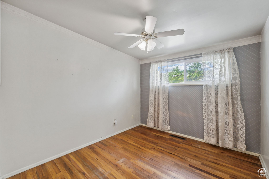 Empty room with ceiling fan and hardwood / wood-style floors