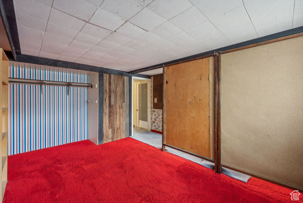 Empty room featuring carpet floors and wood walls