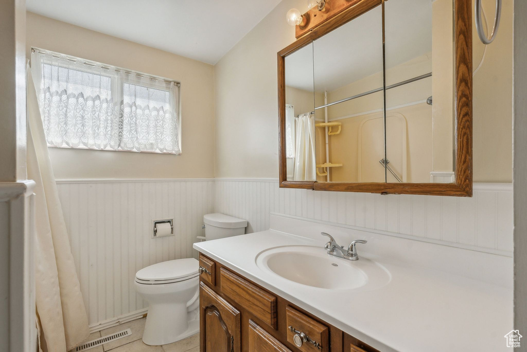 Bathroom with vanity, toilet, a shower with curtain, and tile patterned flooring