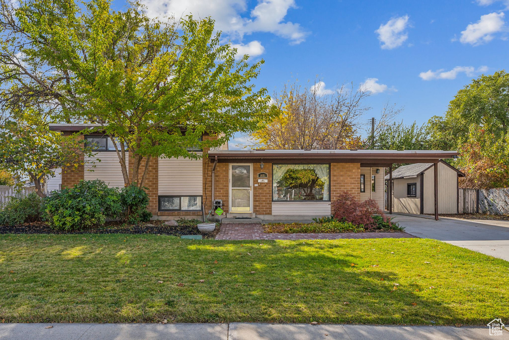 View of front of home featuring a carport and a front yard