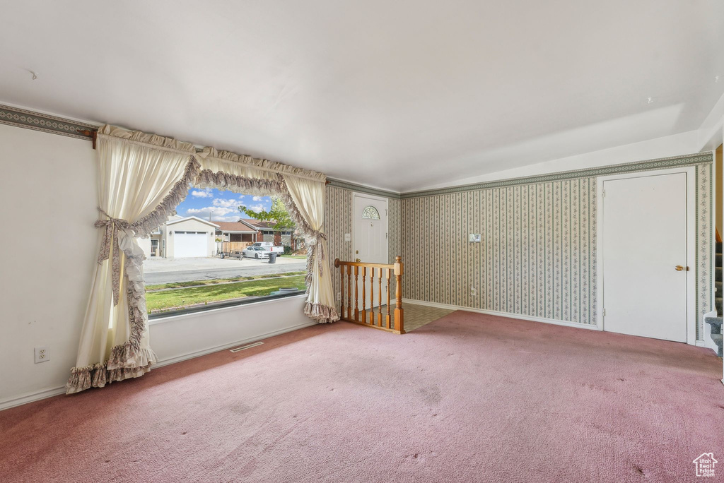 Carpeted empty room with lofted ceiling