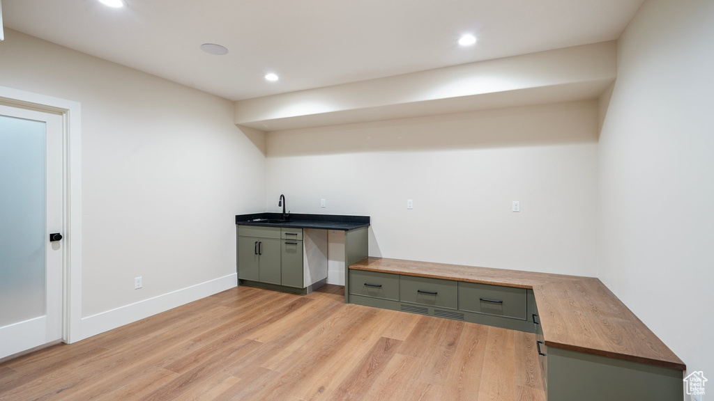 Unfurnished office with sink and light wood-type flooring