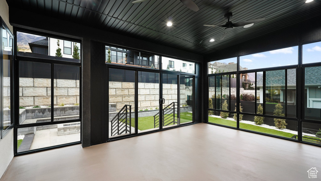 Unfurnished sunroom featuring ceiling fan