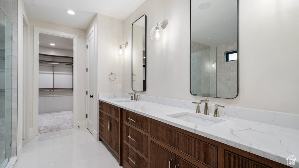 Bathroom featuring vanity, a shower with shower door, and tile patterned floors