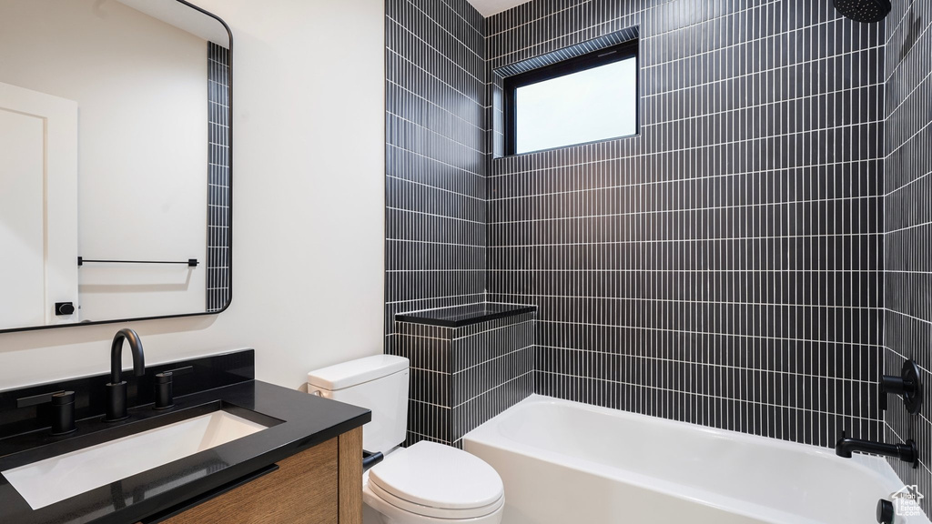 Full bathroom with vanity, toilet, and tiled shower / bath combo