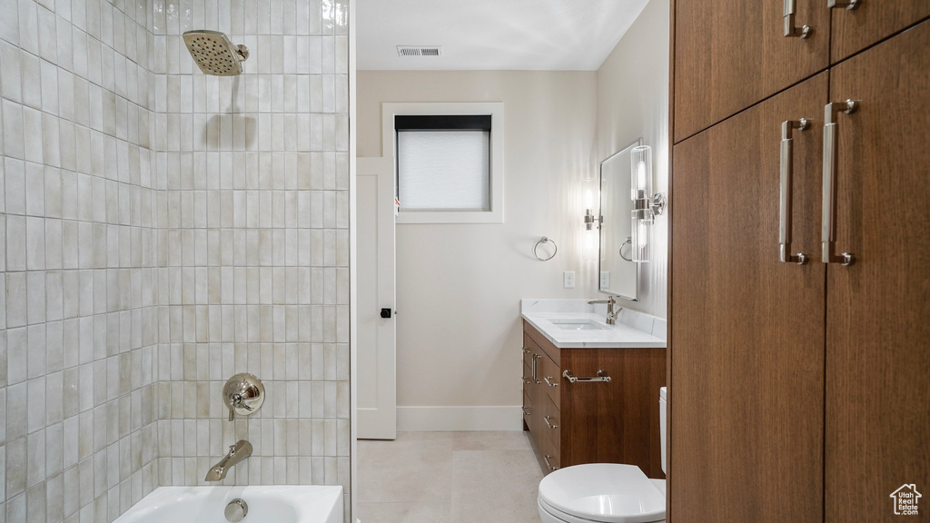 Full bathroom featuring vanity, toilet, and tiled shower / bath