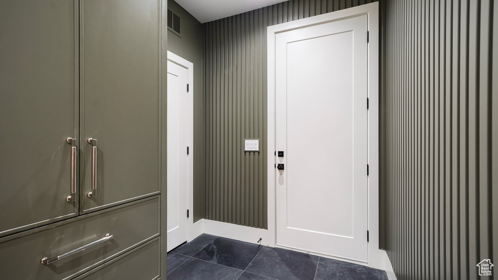 Doorway with dark tile patterned floors